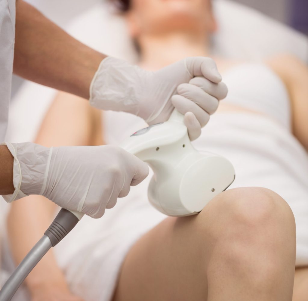 Woman getting anticellulite and anti fat therapy in clinic